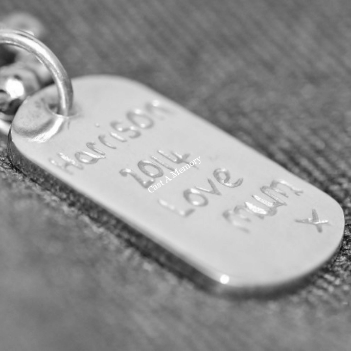 silver dog tag charm engraved with names