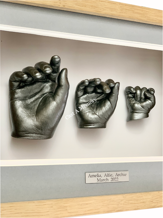 Three separate child hand casts in frame