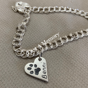 small bracelet with a dog paw print on silver heart shaped charm and engraving of name Benni