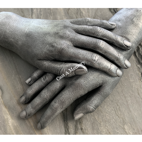 life cast of two hands together on wooden base