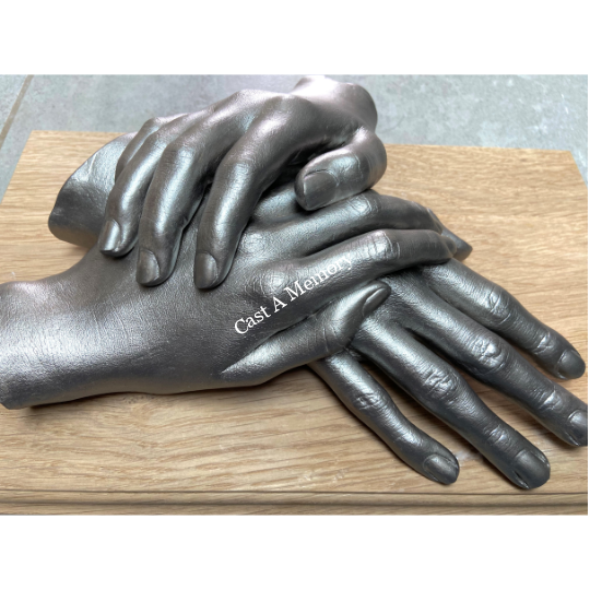 life cast of three hands together on wooden base