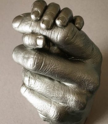 silver life cast of a mother and child's hands in a clasp