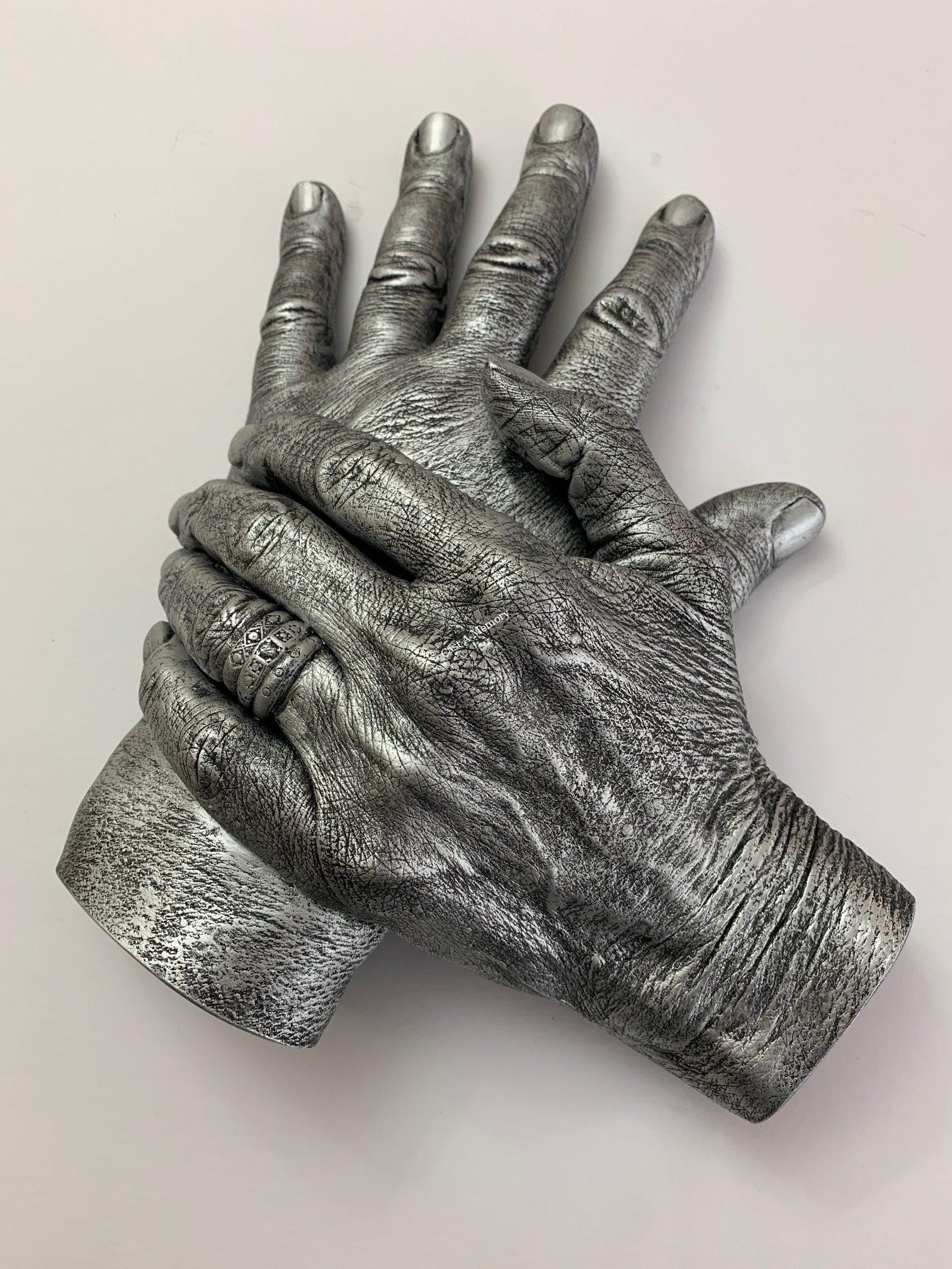 flat horizontal family life cast showing two hands with rings
