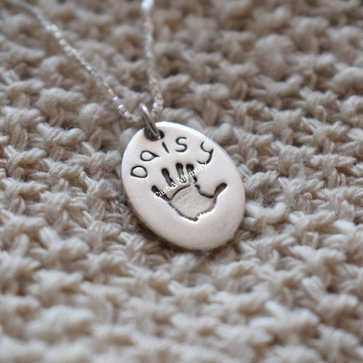oval charm with handprint and name