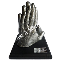 silver life casting of a couples hands on wooden mount